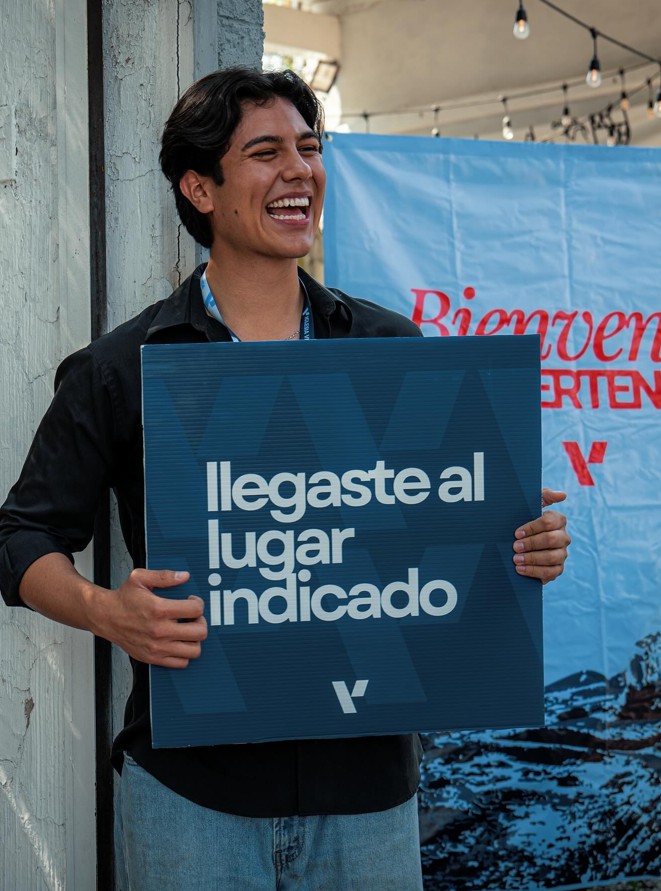joven sonriendo con letrero